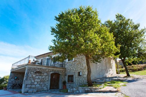 Guardiaregia可可乐旅馆的带阳台和树的石头房子
