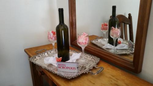 科林斯雅典卫城酒店的镜子前的桌子上放着两瓶葡萄酒