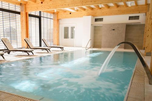 日利纳Hotel Château Gbeľany的室内游泳池,带热水浴池和2把椅子