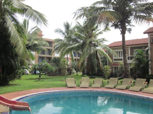 坎多林FF-1 Apartment的一个带椅子和棕榈树的游泳池的度假酒店