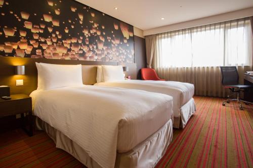 桃园市桃花园饭店的酒店客房配有两张床和一张书桌