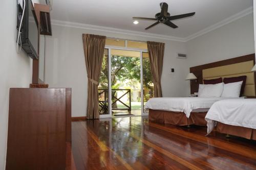 京那律兰卡莎巴斯海滩度假村的一间卧室配有两张床和吊扇
