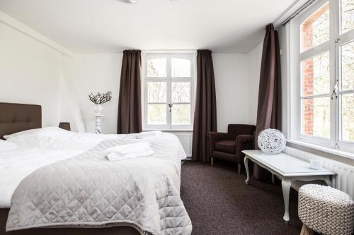 GoirleKlooster Nieuwkerk Goirle的一间卧室配有一张床、一把椅子和窗户。