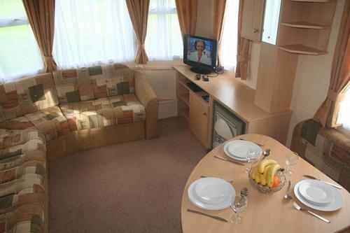 兰贝德Dinas的客厅配有桌子和沙发