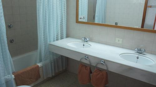 波多黎各Spacious flat with ocean view的浴室设有2个水槽、镜子和浴缸。