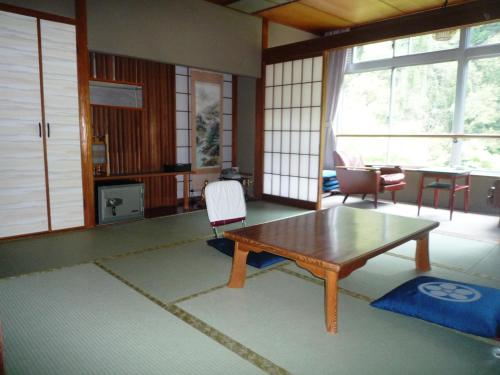 京都高尾山观光酒店的客厅配有木桌和椅子