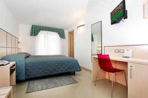 托尔博莱莫耶里酒店的一间卧室配有一张床、一张桌子和一把红色椅子