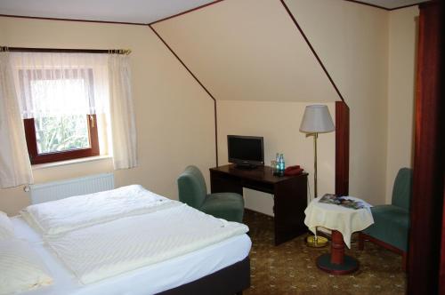Burgstaedt金狮乡村酒店及陶拉施泰因旅馆的酒店客房配有一张床、一张书桌和一台电视。