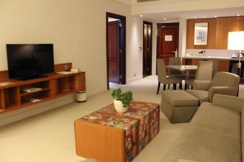 多哈多哈K108酒店的客厅配有电视、沙发和桌子