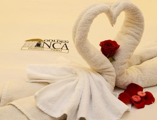 库斯科金印加酒店的两个天鹅在玫瑰旁的毛巾上裹着