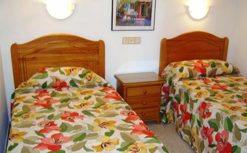 英格兰海滩塔玛拉吉奥公寓酒店的卧室内两张并排的床