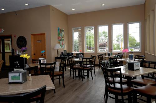 DenisonCobblestone Inn & Suites - Denison | Majestic Hills的用餐室设有桌椅和窗户。