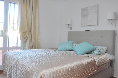 阿尔科斯-德拉弗龙特拉Casa Sandra的一间卧室配有一张带蓝色枕头的床。