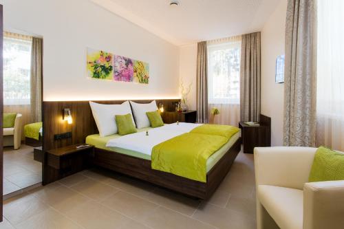 萨尔茨堡维尔德别墅住宿加早餐旅馆的一间卧室配有一张带绿毯的大床