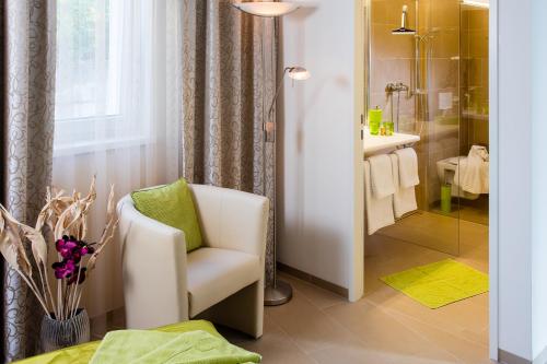 萨尔茨堡维尔德别墅住宿加早餐旅馆的一间带白色椅子和淋浴的浴室