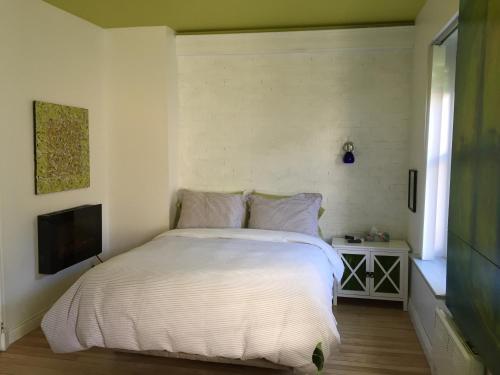 魁北克市乐253号住宿加早餐旅馆的卧室配有白色的床和电视。