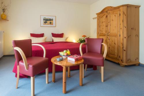 巴特布雷希格Hotel Fontana - ADULTS ONLY的一间卧室配有一张床、两把椅子和一张桌子