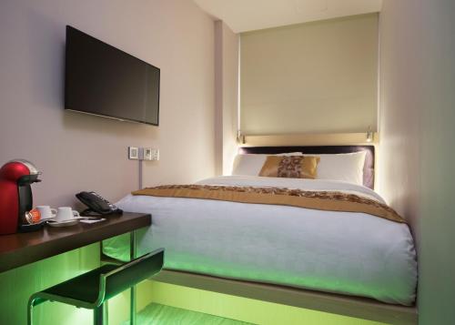 新加坡Hotel Clover 7的一间卧室配有一张床和一张带电话的书桌