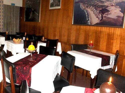 波尔蒂芒Sao Roque的一间用餐室,配有白色的桌椅和蜡烛