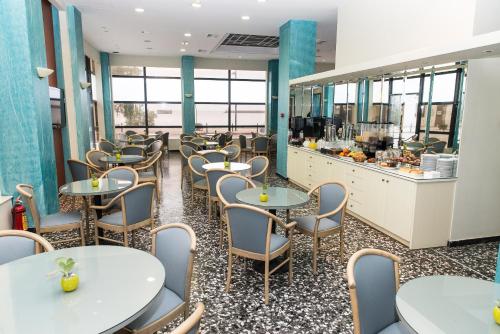 卡拉马塔奥斯特里亚酒店的一间带桌椅和柜台的餐厅
