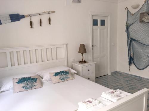 马里迪莫伊尔科拉洛公寓的卧室配有白色的床和2个枕头