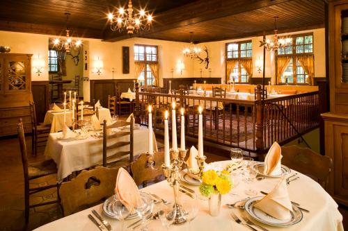 阿尔夫伯格阿拉斯酒店的一间用餐室,配有白色的桌子和蜡烛