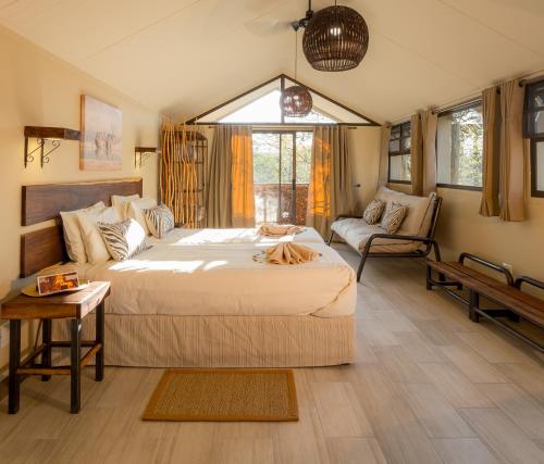 奥考奎约埃托沙村酒店的一间卧室配有一张大床和一张沙发
