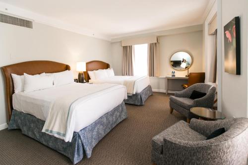 伊斯顿泰德沃特酒店的酒店客房带一张大床和两张椅子
