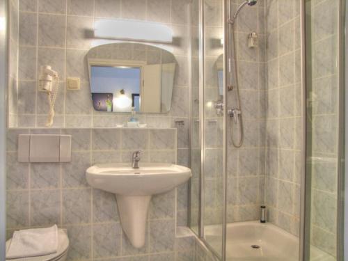 萨斯尼茨海之宴酒店的一间带水槽和玻璃淋浴的浴室