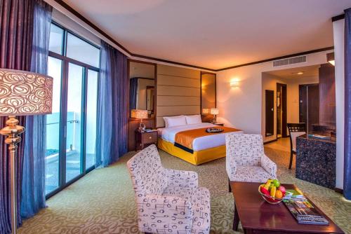 瓜埠兰卡威阿迪雅酒店的酒店客房带一张床、一张桌子和椅子