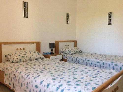 纳布勒Villa Kenza的一间卧室设有两张床和床头柜