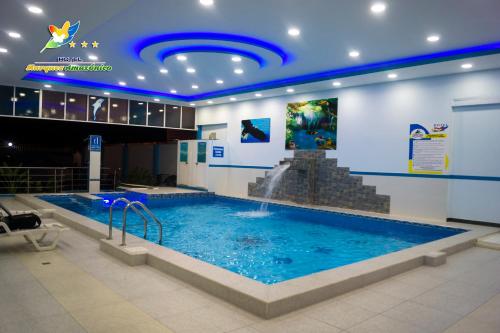 新洛哈Hotel Marques Amazonico的一座大型游泳池,在一座建筑中设有喷泉