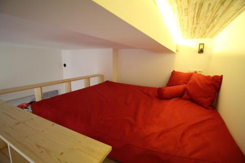 考纳斯老城公寓的一间卧室配有一张带红色毯子的床