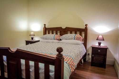 布罗肯希尔Heather's Mica Cottage的一间卧室配有木床和2个床头柜