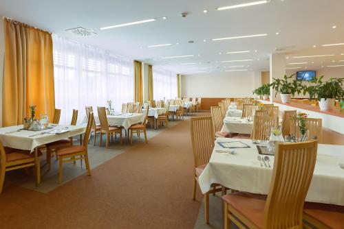 普雷绍夫黎奈思酒店的一间设有白色桌椅的用餐室