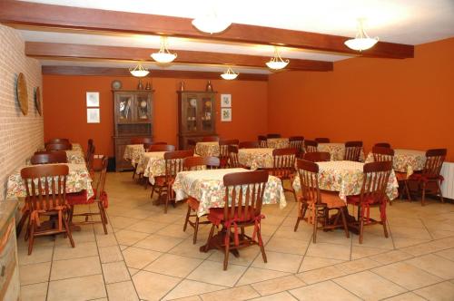 坎波斯杜若尔当夏布利酒店的用餐室设有桌椅和橙色墙壁
