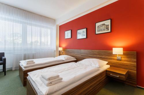 俄斯特拉发弗洛妮卡酒店的红色墙壁的客房内的两张床