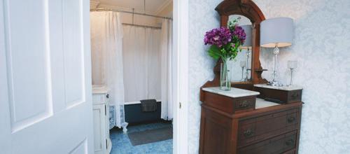 五月岬郡The Harrison Inn的浴室设有镜子和花瓶装梳妆台