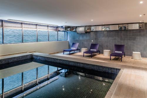 巴鲁埃里阿尔法村蓝树高级酒店的游泳池旁设有两把椅子