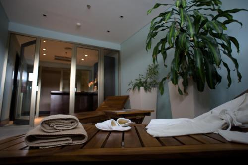 罗卡将军市Hotel y Casino Del Río - General Roca的一张带毛巾和植物的木桌