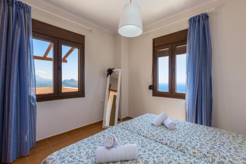 SellíaAnastasia Villa, view to Libyan sea, By ThinkVilla的一间卧室设有一张床和两个窗户。