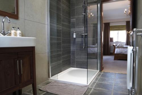 ChinleyThe Lamb Inn的一间带玻璃淋浴和水槽的浴室