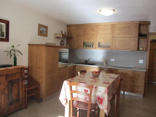 雷梅斯-诺特雷-达梅Les Racines的厨房配有木制橱柜和带桌布的桌子。