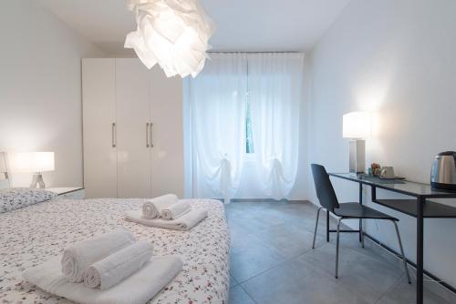 维罗纳修道院公寓的白色卧室配有书桌和床