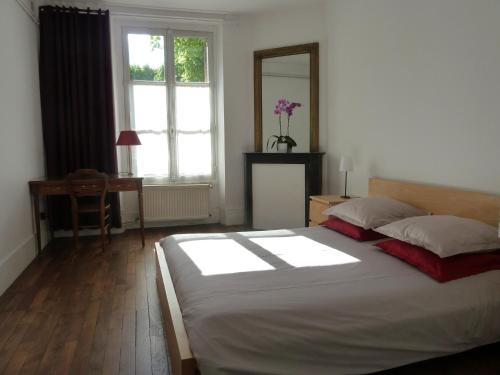 凡尔赛莱斯卡瑞斯酒店的一间卧室配有一张床、一张书桌和一个窗户。