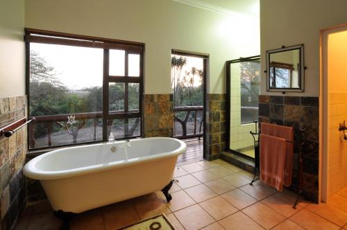 赫卢赫卢韦豪鲁维河旅舍的带浴缸和窗户的大浴室