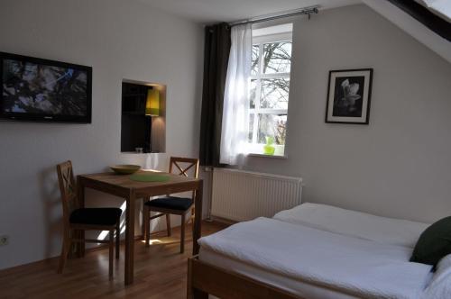 策勒Apartment Brauner Hirsch的一间卧室配有桌子、床和窗户