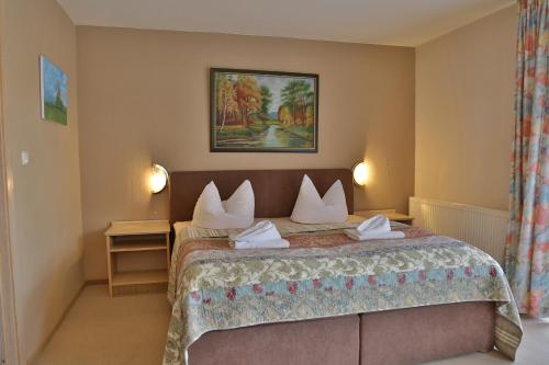 Lalendorf伊姆维森古德酒店的配有两张枕头的床的酒店客房