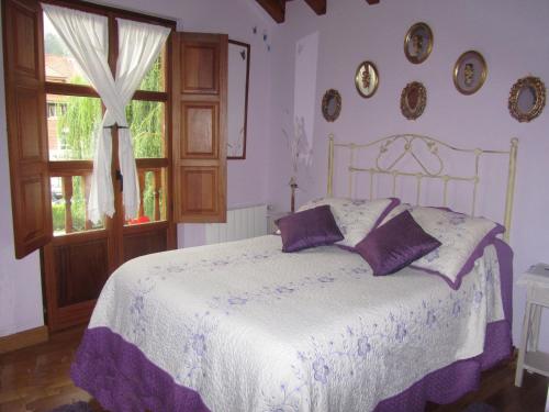 蓬特维耶斯戈波萨达德尔帕斯酒店的一间卧室配有一张带紫色枕头的床和窗户。