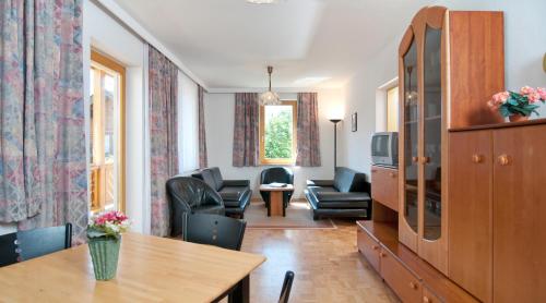 法克湖Gästehaus Lutschounig的客厅配有桌椅和电视。